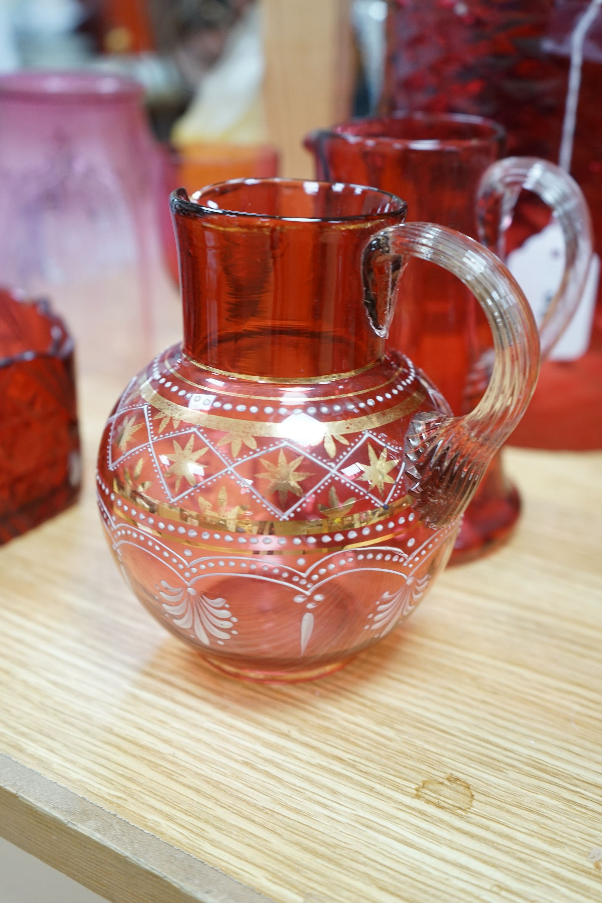 Three cranberry glass shades together with mixed cranberry and other glass, tallest shade 23cms high